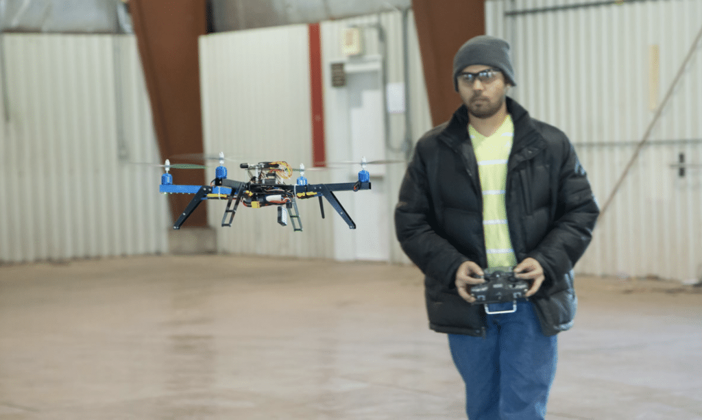Man flying drone in building