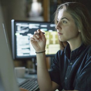 Woman monitors dark office Woman monitors dark office